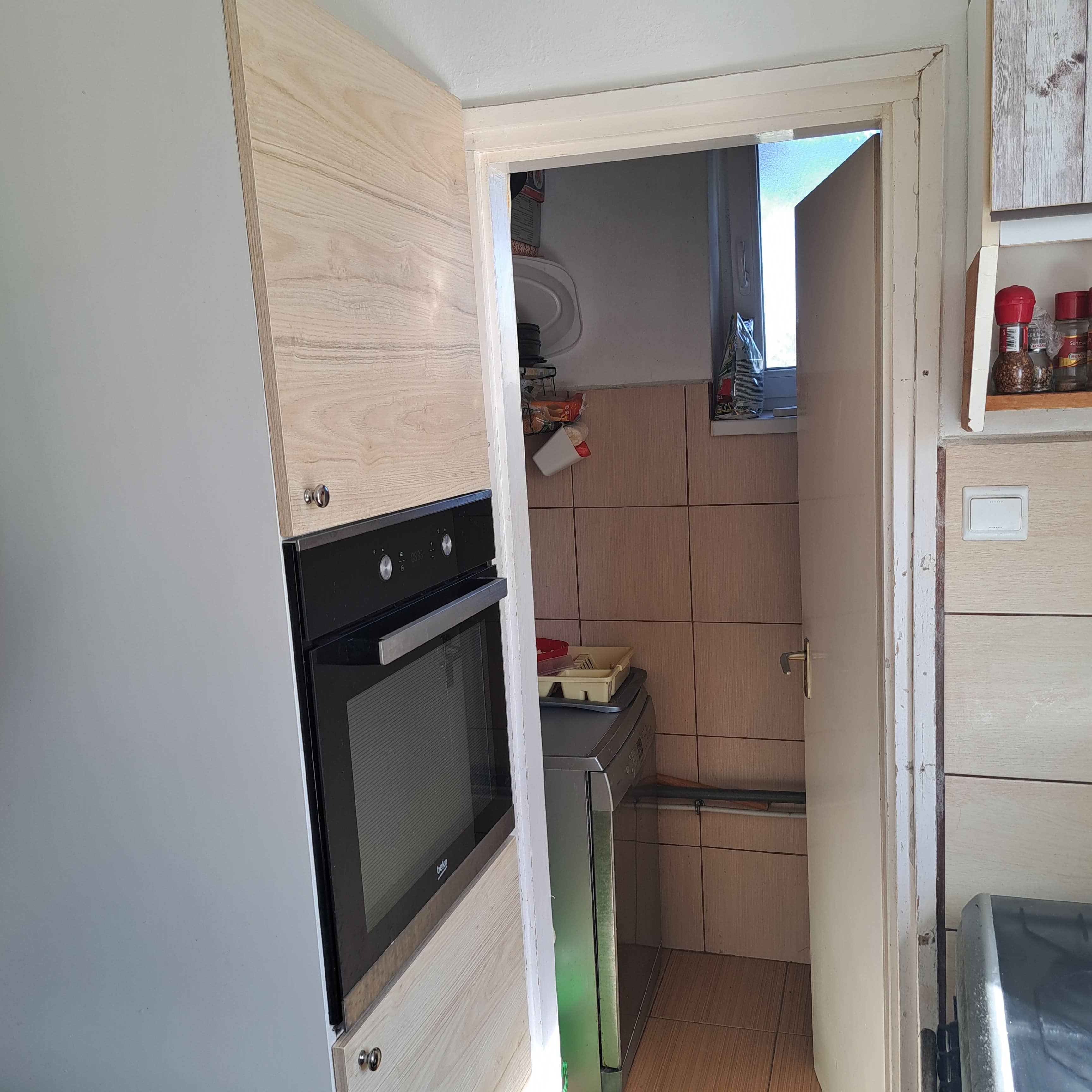 Világos konyha kényelmes munkafelülettel és kamrakapcsolattal