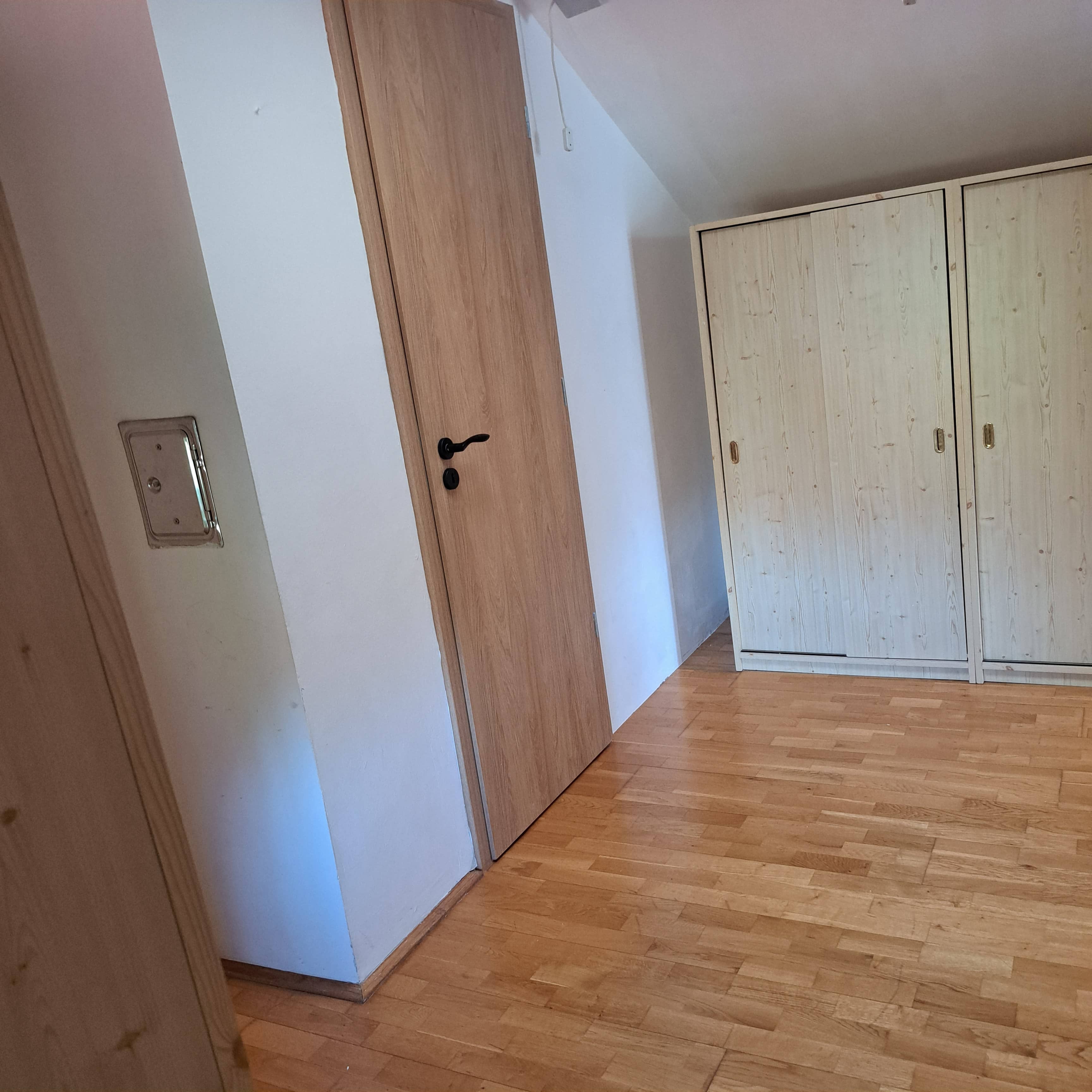 Tetőtéri hálószoba lambériázott fallal és tetőablakkal