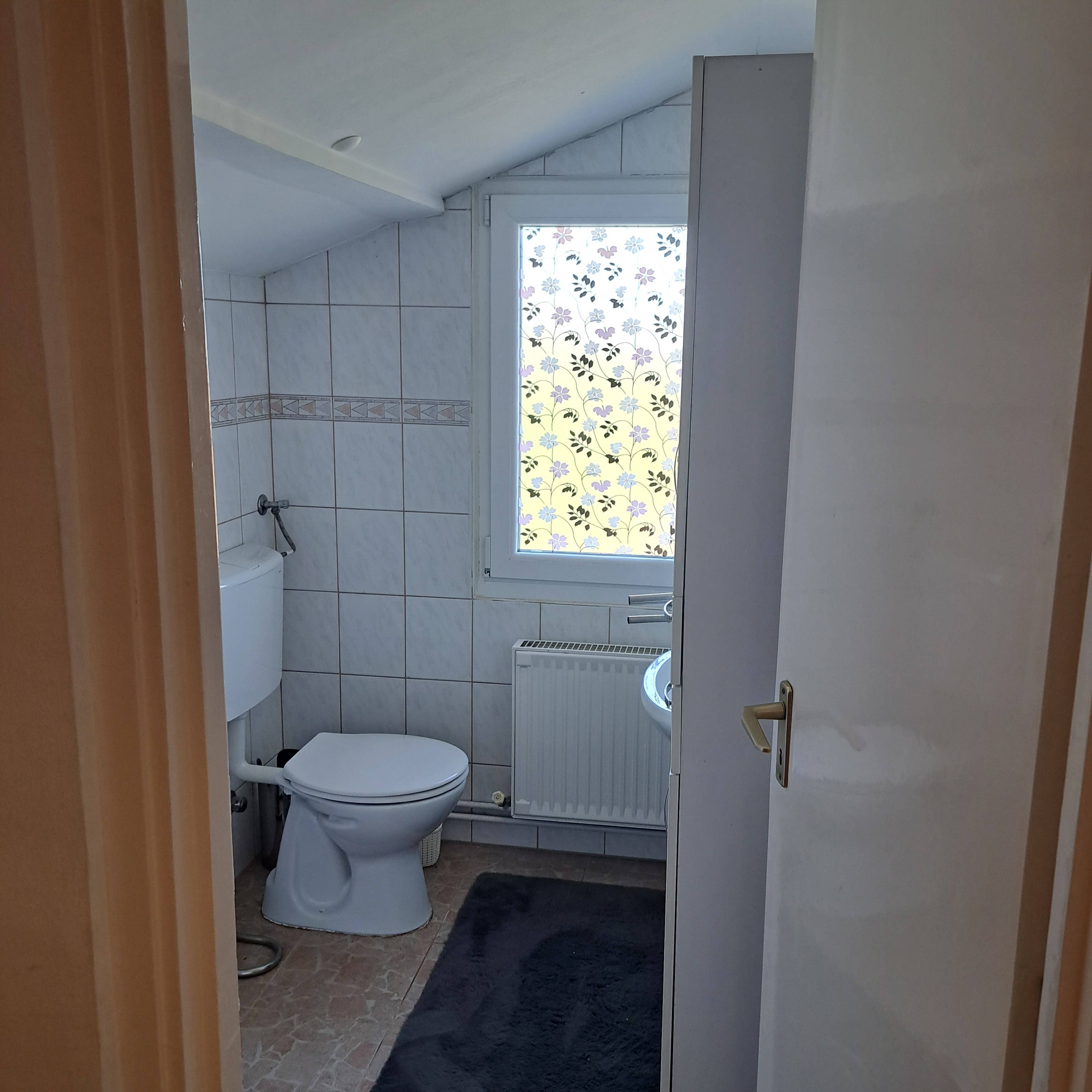 Tetőtéri zuhanyzós fürdőszoba modern mosdóval