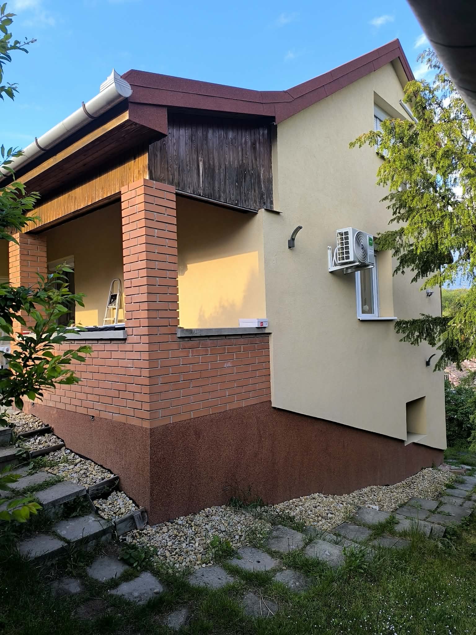 Felújított családi ház bejárata és a parkosított udvar Pécelen